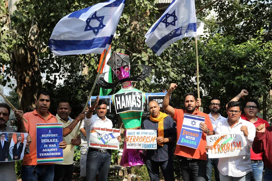 epa10935723 Pro-Israel supporters hold placards next to an effigy of the demon king Ravana depicting militant group Hamas during a protest in New Delhi, India, 24 October 2023. Thousands of Israelis and Palestinians have died since the militant group Hamas launched an unprecedented attack on Israel from the Gaza Strip on 07 October, and the Israeli strikes on the Palestinian enclave which followed it.  EPA-EFE/RAJAT GUPTA