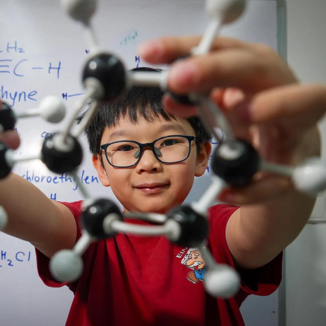 Chemistry prodigy Theodore Kwan, seven, holding an isopropyl benzene model he built.