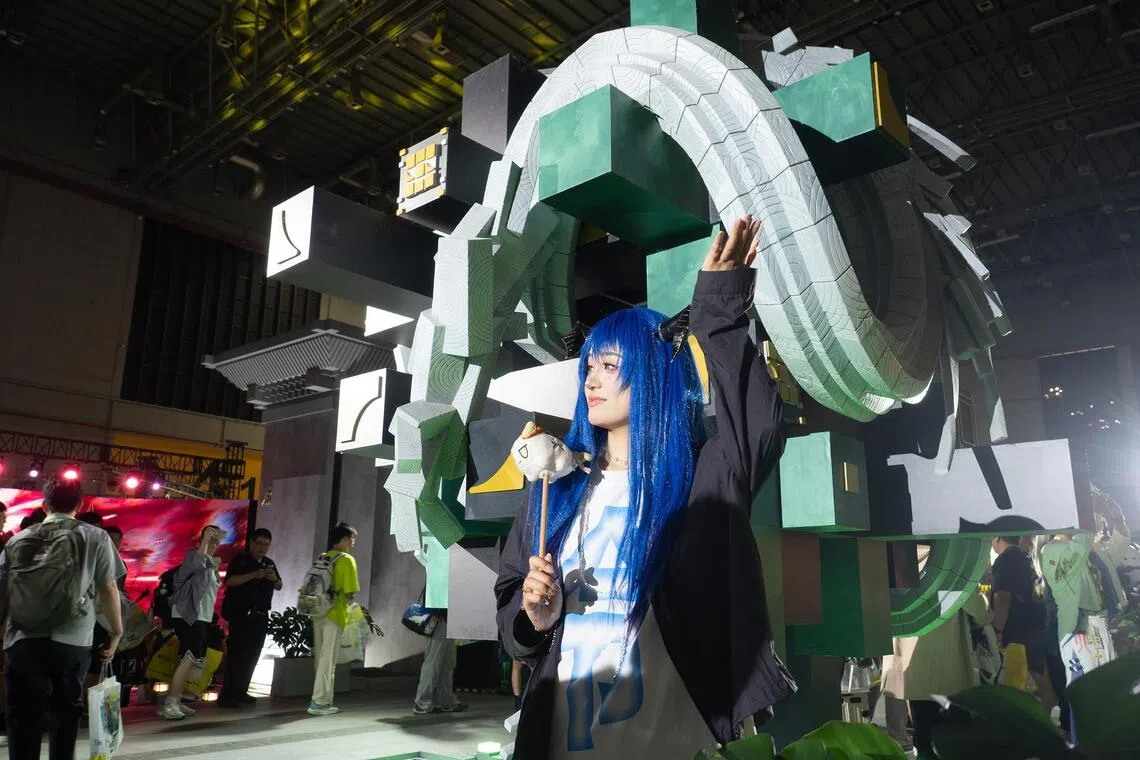 An attendee cosplaying as Mostima from the mobile game Arknights poses for photos.