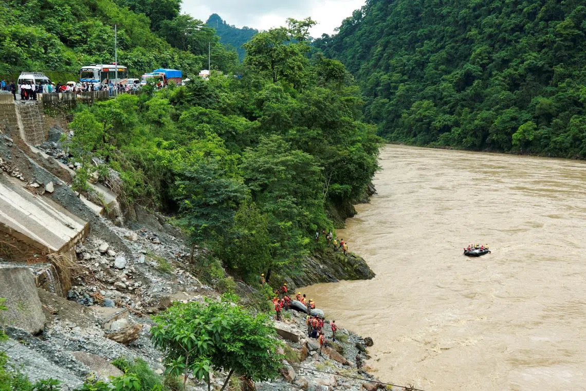 Rescuers search for the passenger buses that fell into the Trishuli River after the landslide at Simaltal area in Chitwan district, Nepal.