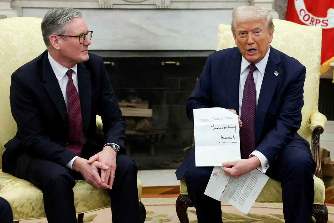 FILE PHOTO: U.S. President Donald Trump holds a letter from Britain's King Charles as he meets with British Prime Minister Keir Starmer in the Oval Office at the White House in Washington, D.C., U.S., February 27, 2025. REUTERS/Kevin Lamarque/File Photo