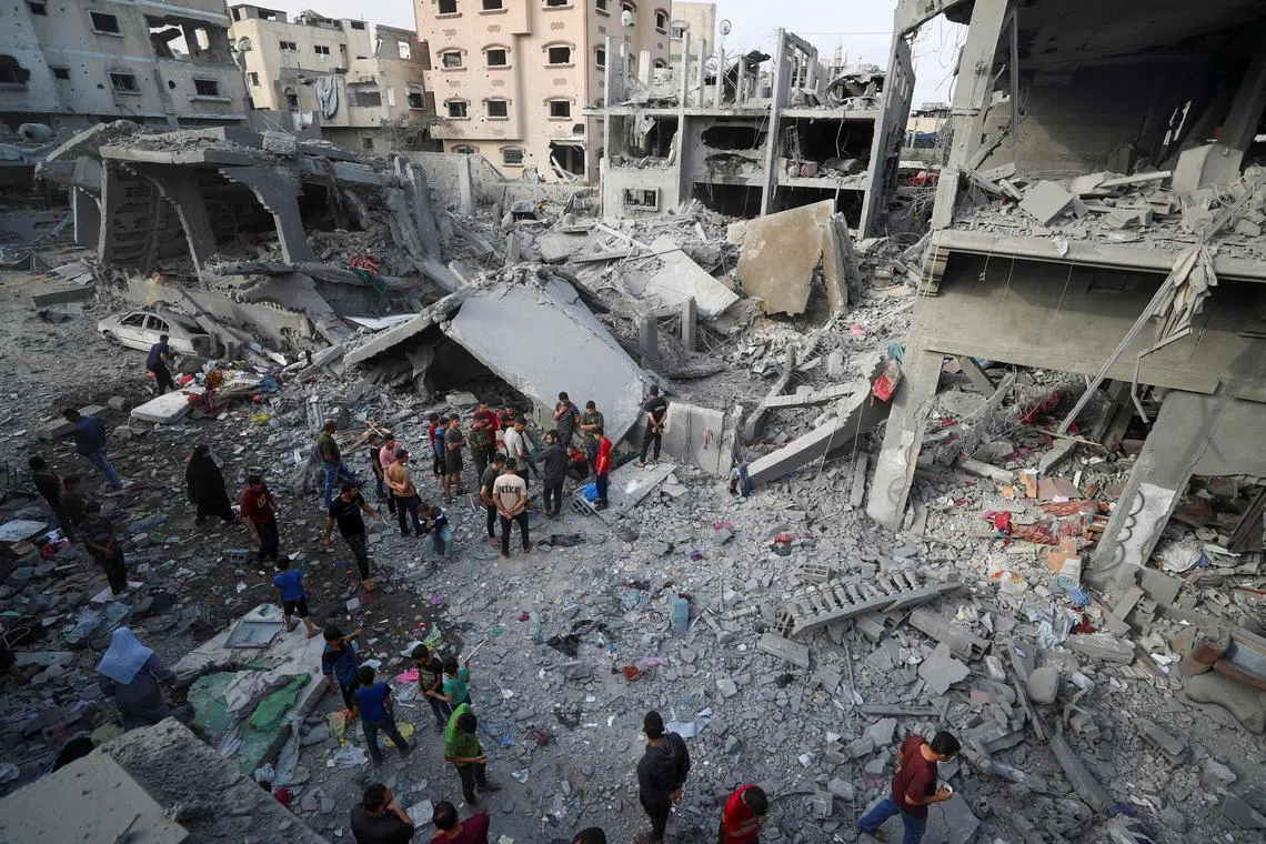 Palestinians inspect the site of an Israeli strike on a house, in Jabalia, northern Gaza Strip May 18, 2025. REUTERS/Mahmoud Issa