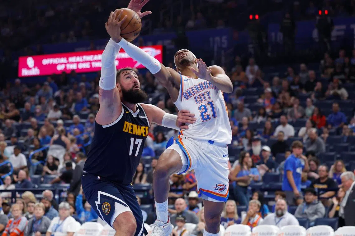 Oklahoma City Thunder guard Aaron Wiggins goes up for a basket in front of Denver Nuggets center Jonas Valanciunas during a pre-season game.