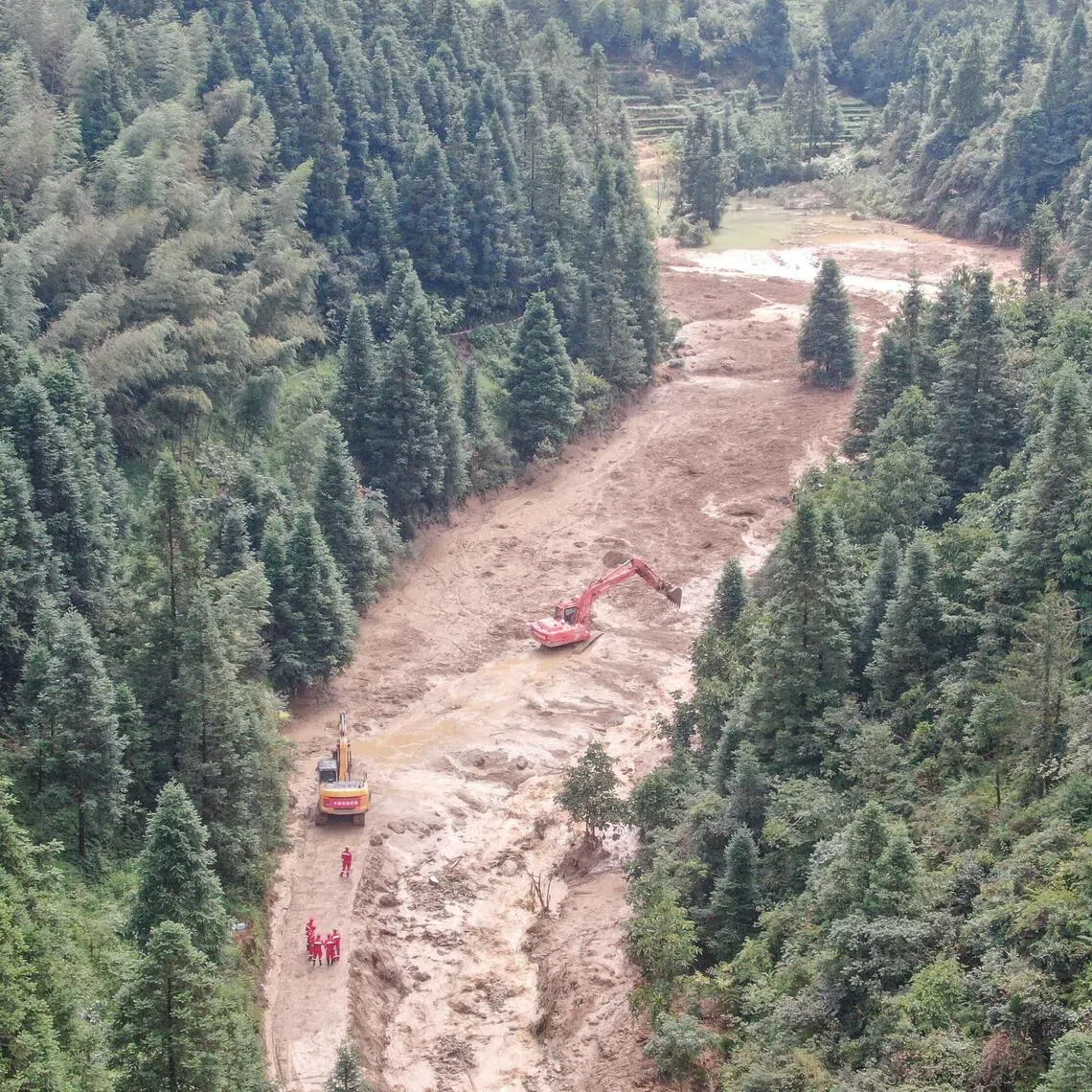 A drone view shows construction machinery clearing a road to the mudslide-hit Mingkeng village after heavy rainfall associated with Typhoon Saudel.