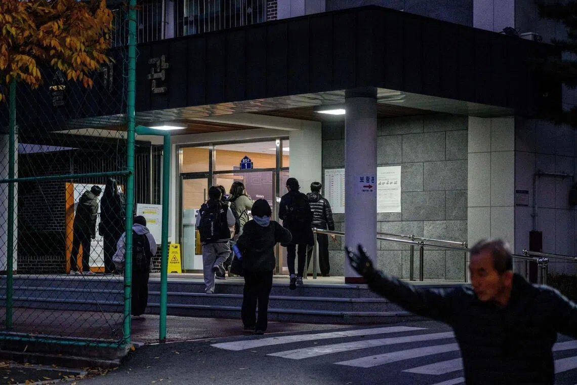 Students arrive (back) for the annual college entrance exam, known locally as Suneung, at the Gwangnam High School, in Seoul, on November 13, 2025. (Photo by ANTHONY WALLACE / AFP)