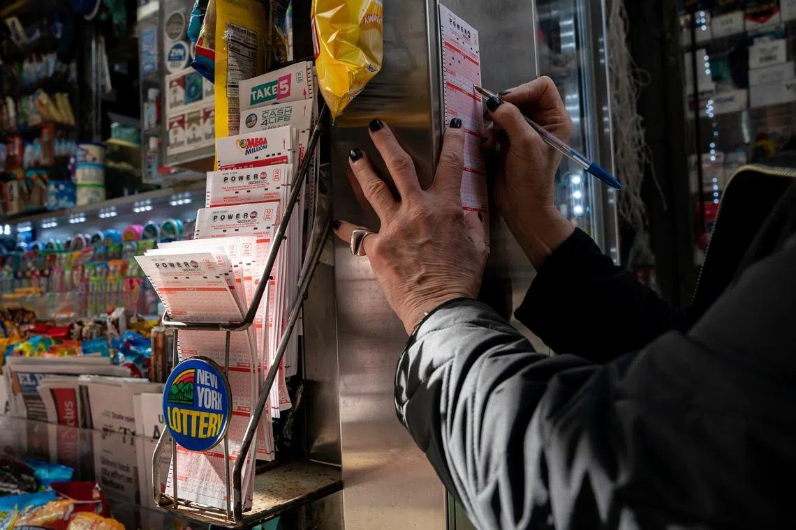 A person fills out a Powerball play slip for the 1.6 billion dollar jackpot in New York City, U.S., November 4, 2022. REUTERS/David 'Dee' Delgado
