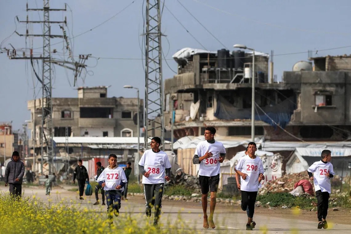 Damaged buildings in the Bureij camp for Palestinian refugees in the central Gaza Strip are seen in this photo from on March 27, 2026. Violence has persisted in Gaza despite a ceasefire in October 2025, though life goes on as shown by these runners who were taking part in a marathon event.
