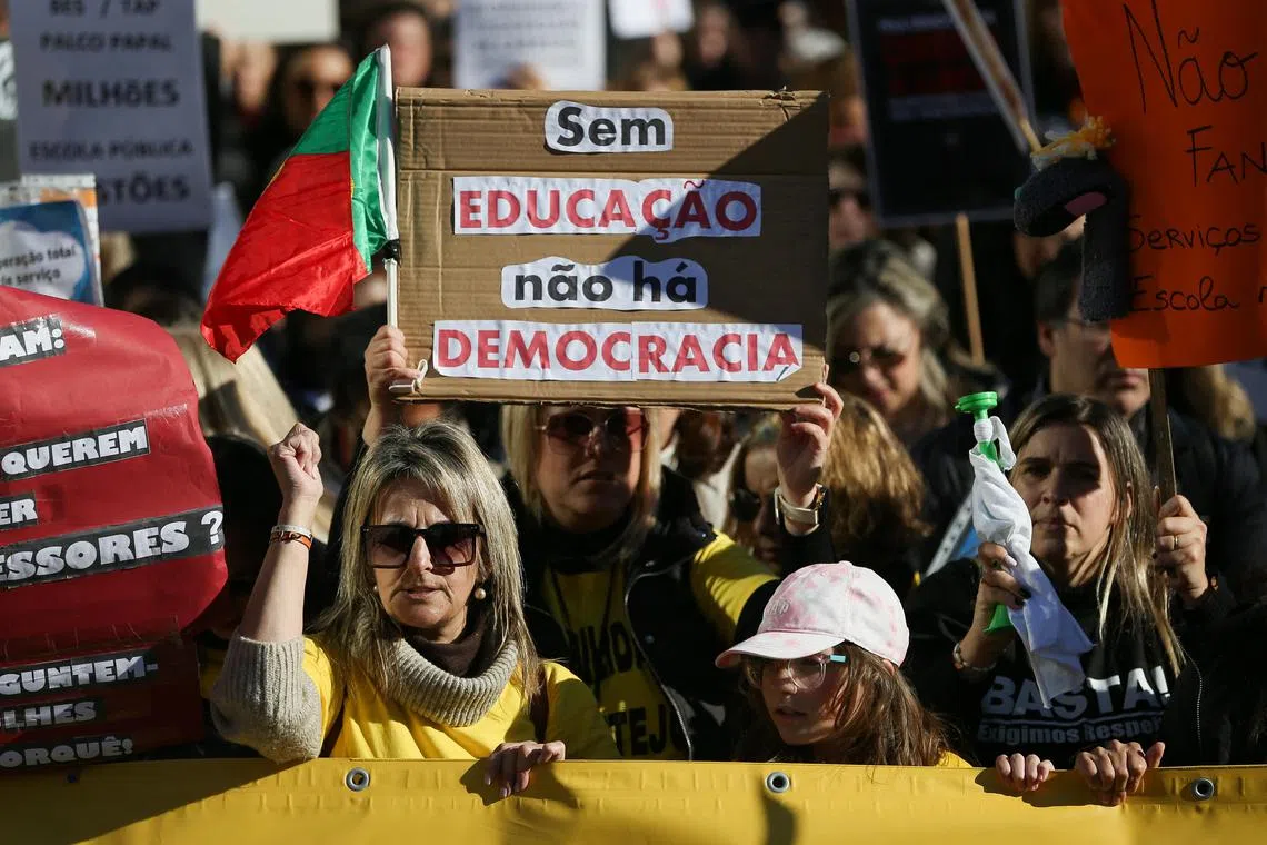 A person carries a banner reading "Without education, there is no democracy", as school workers demonstrate for better salaries and working conditions, in Lisbon.
