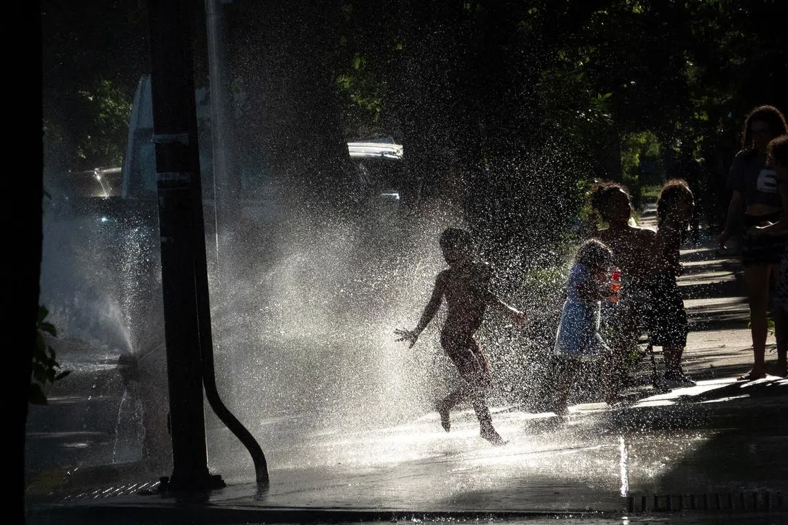 Kids play in an open fire hydrant as temperatures climbed into the mid-90s on June 23, 2025, in Chicago, Illinois. 