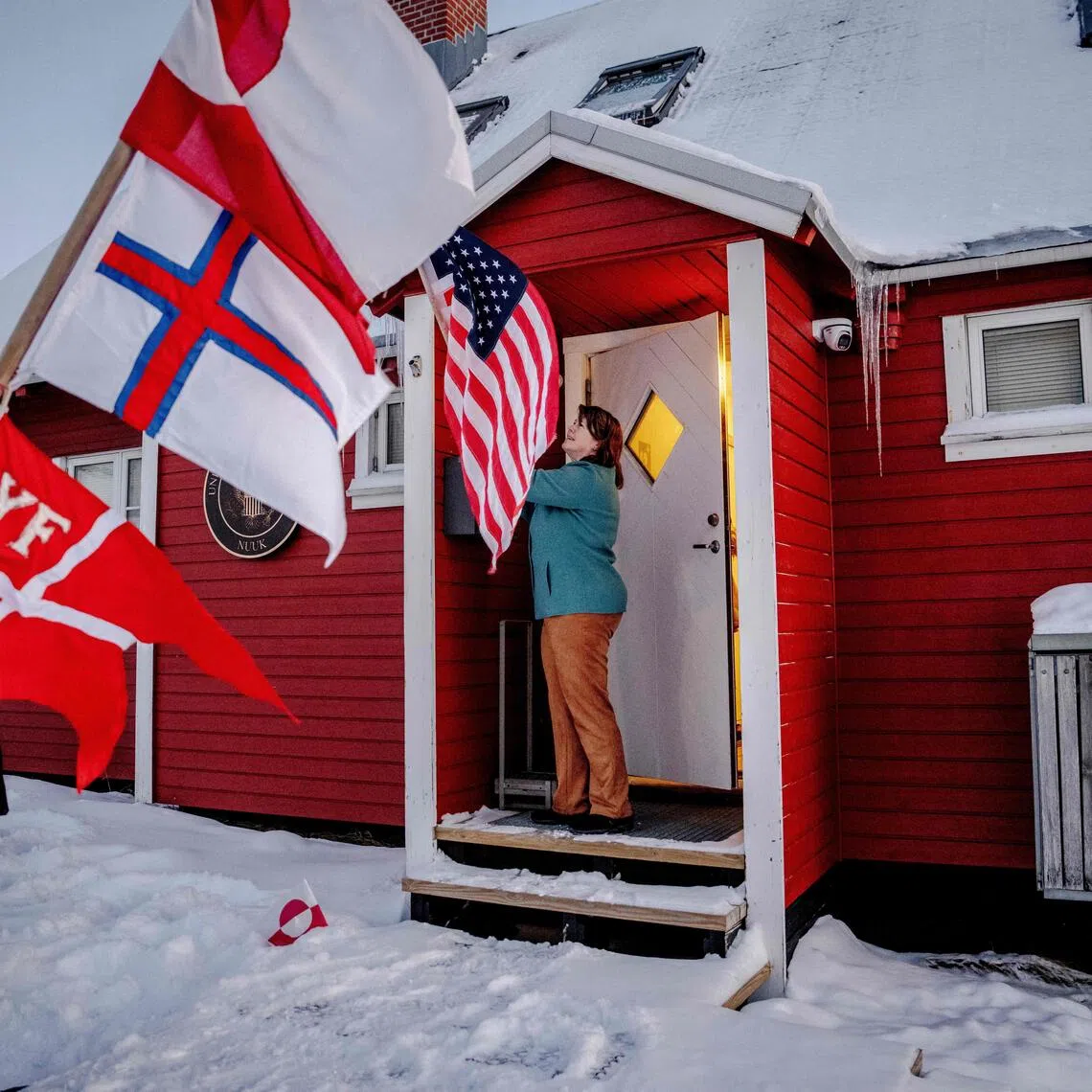 A protester holds a flag outside the US consulate in Nuuk, Greenland.