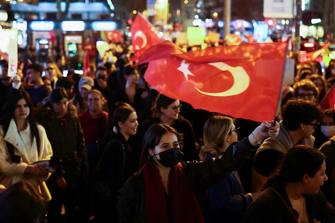 A woman holds a Turkish flag during a protest against the arrest of Istanbul Mayor Ekrem Imamoglu as part of a corruption investigation, in Istanbul, Turkey, March 26, 2025. REUTERS/Emilie Madi