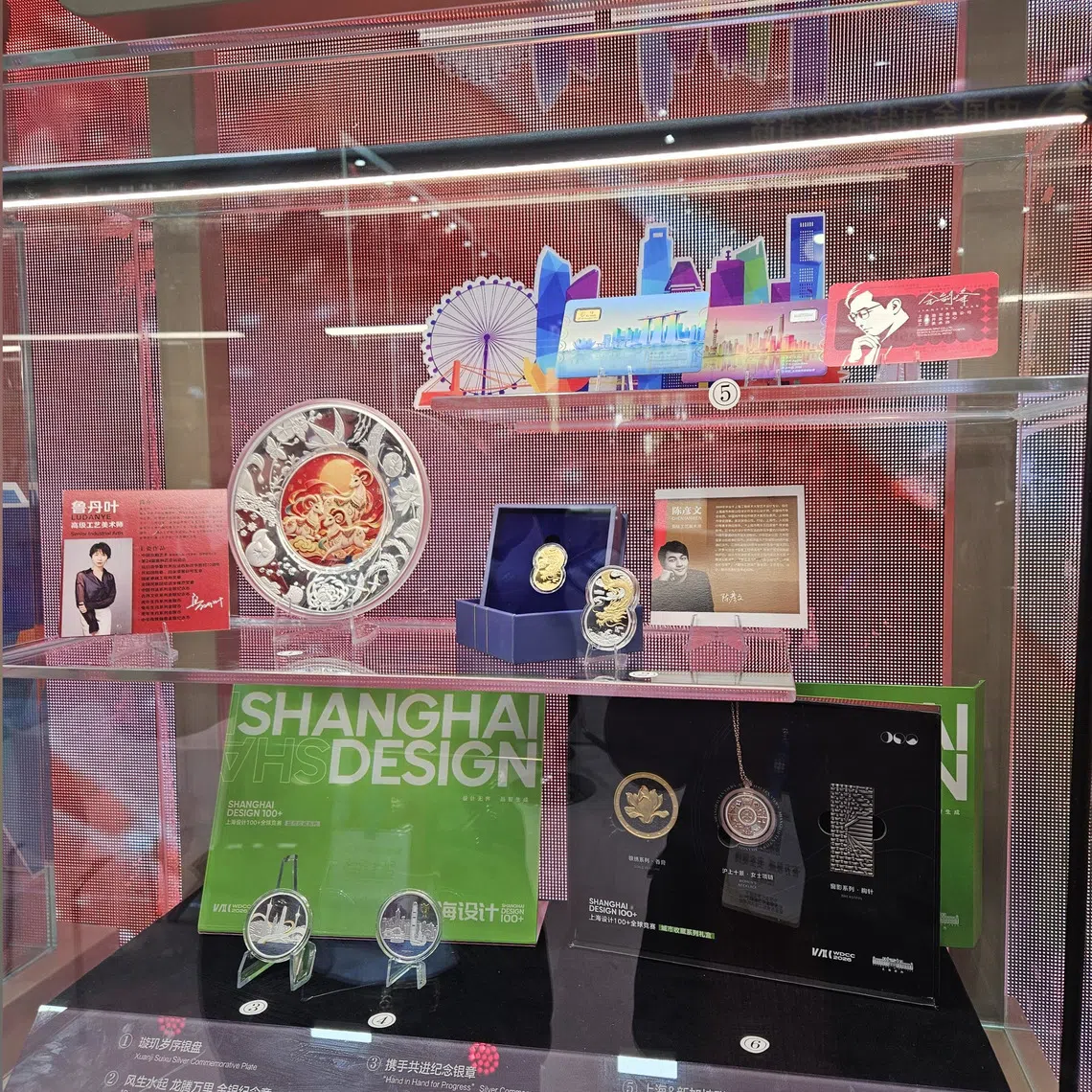 The “Rising Fortunes, Soaring Dragon and Majestic Lion” gold and silver commemorative medallions are seen on display at the Beijing International Coin Exposition on Oct 30.