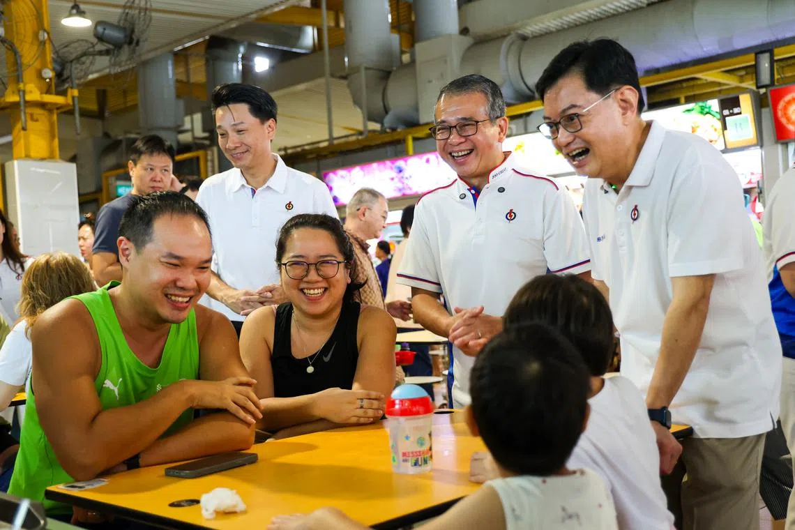 Deputy Prime Minister and East Coast GRC MP Heng Swee Keat (right) and Minister for Culture, Community and Youth Edwin Tong (second from right) on a walkabout at the food centre at Block 16 Bedok South Road on March 23.