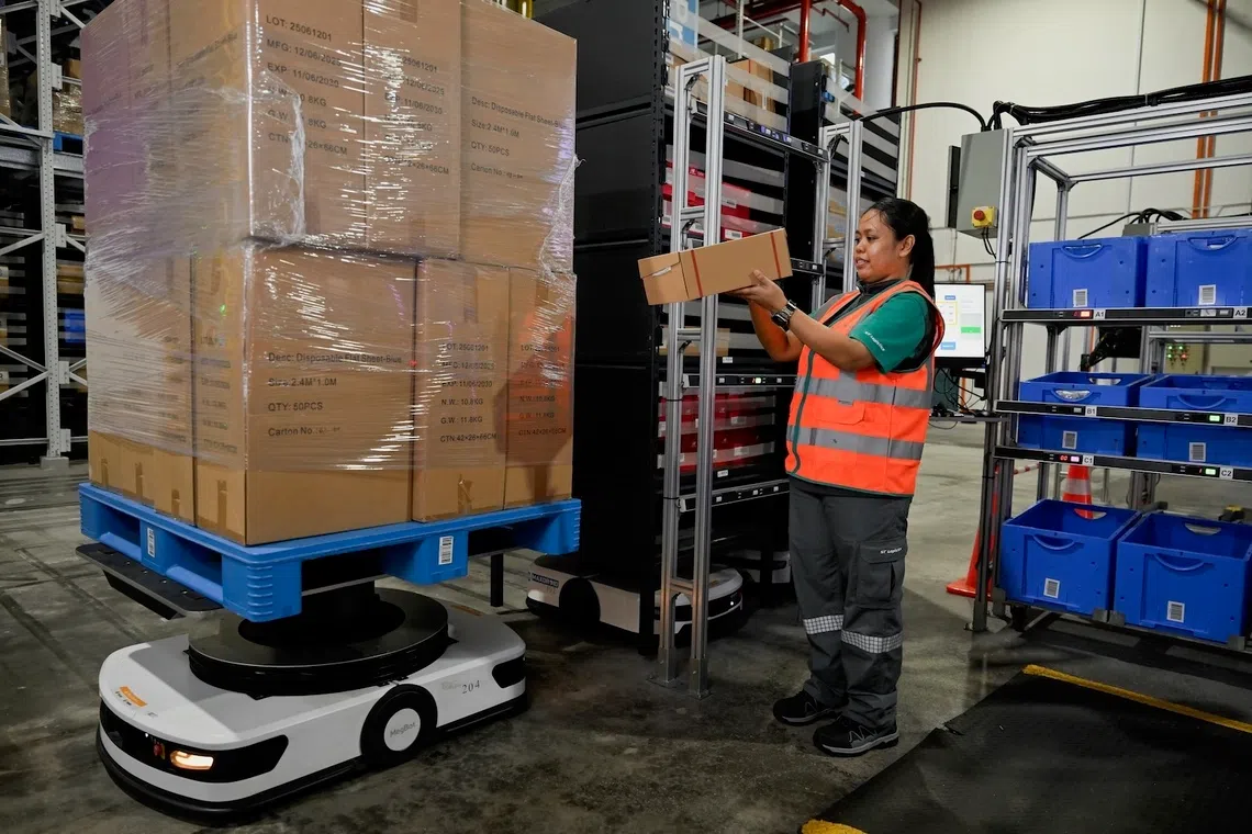 With support from her employer ST Logistics, Marnihidahyuni Tohani reskilled herself and through on-the-job training, learned how to use autonomous robots in her work.
