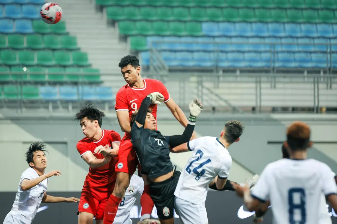 Singapore’s Jordan Emaviwe (9, red) fighting for the ball against Cambodia’s goalkeeper Reth Lyheng (21, black) in the Merlion Cup Under-22s 3rd/4th playoff held at Jalan Besar Stadium, March 26, 2023.