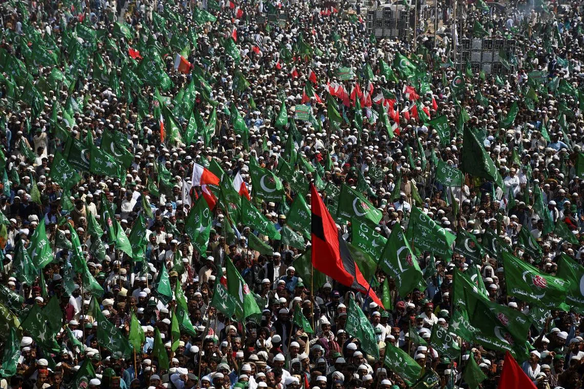 Supporters of the Grand Democratic Alliance (GDA), an alliance of political parties, carry flags as they gather for a sit-in protest against, what they call election rigging and are demanding free and fair results of the general elections along the main Highway in Jamshoro, Pakistan February 16, 2024. REUTERS/Yasir Rajput/File Photo