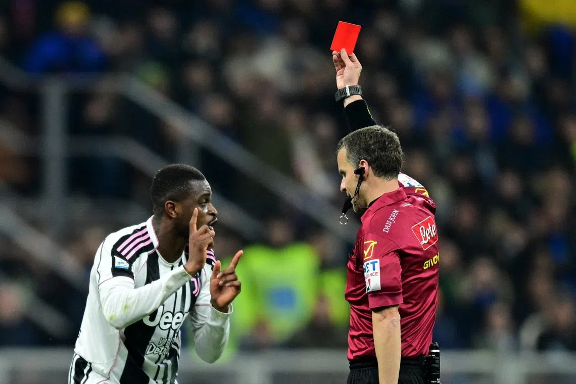Soccer Football - Serie A - Inter Milan v Juventus - San Siro, Milan, Italy - February 14, 2026 Juventus' Pierre Kalulu is shown a red card by referee Federico La Penna REUTERS/Daniele Mascolo