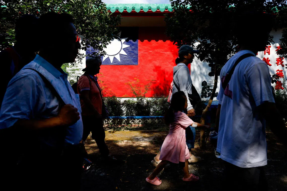 Tourists walk past a wall painted with a Taiwan flag, on Dadan Island, Kinmen, Taiwan, October 18, 2025. REUTERS/Ann Wang     TPX IMAGES OF THE DAY