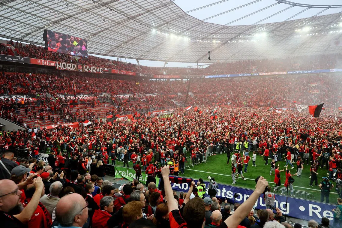 Soccer Football - Bundesliga - Bayer Leverkusen v Werder Bremen - BayArena, Leverkusen, Germany - April 14, 2024 General view of Bayer Leverkusen fans celebrating during a pitch invasion after winning the Bundesliga REUTERS/Wolfgang Rattay