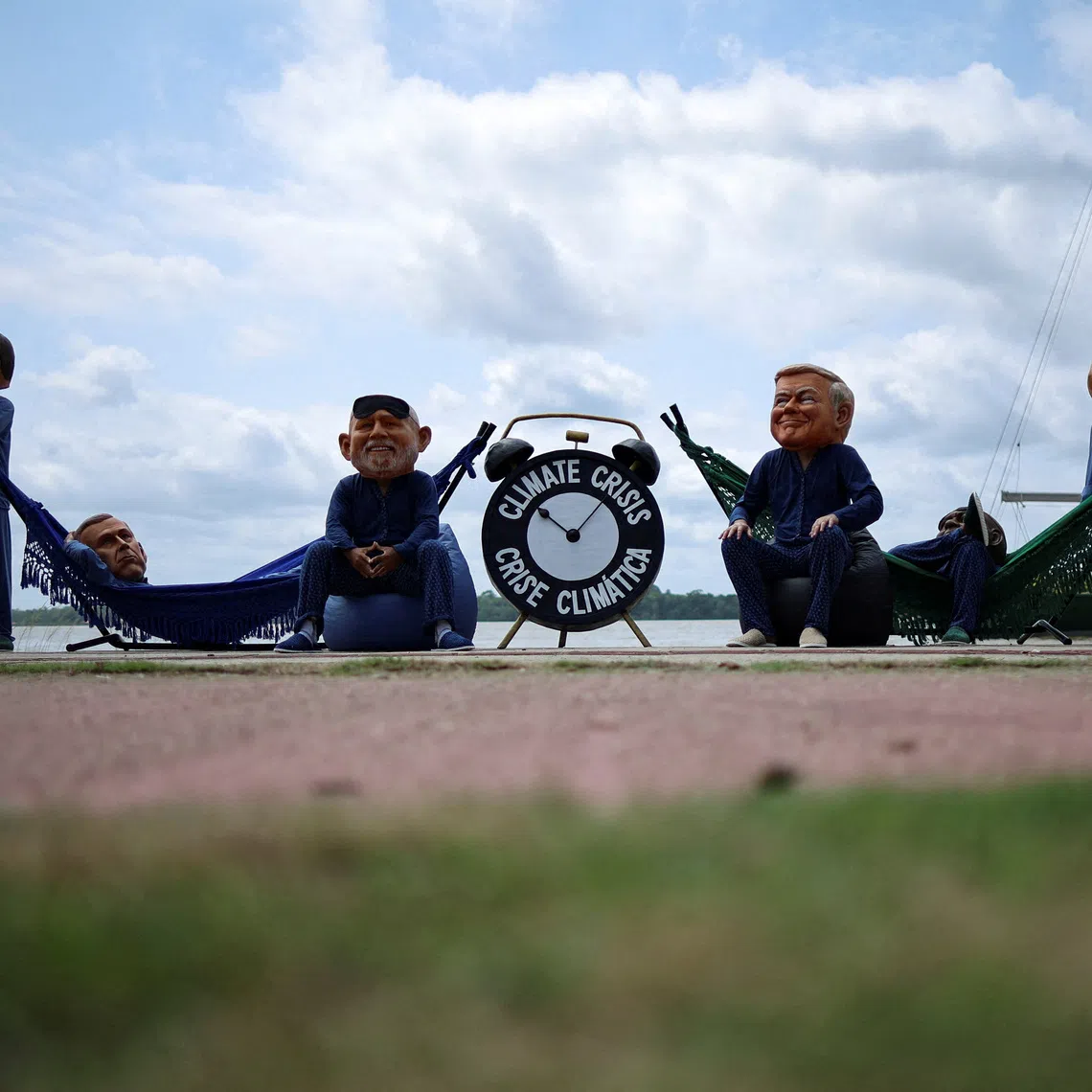 FILE PHOTO: Oxfam activists wearing big head masks depicting world leaders stage a \"Sleeping on the Job\" protest to criticize the inadequacy of decisions made by the world?s largest economies in combating the climate crisis, ahead of the United Nations Climate Change Conference COP30 in Belem, Brazil, November 5, 2025. REUTERS/Adriano Machado     TPX IMAGES OF THE DAY/File Photo