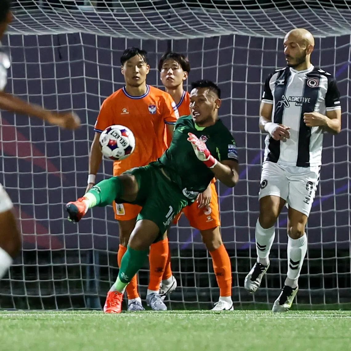ST20251123_202597400123/Dgsoc23/Brian Teo/Deepanraj A C Ganesan/Albirex Niigata goalkeeper Hassan Sunny (centre) clearing the ball during the team's match against Tanjong Pagar United in the Singapore Cup at Jurong East Stadium on Nov 23, 2025. ST PHOTO: BRIAN TEO
