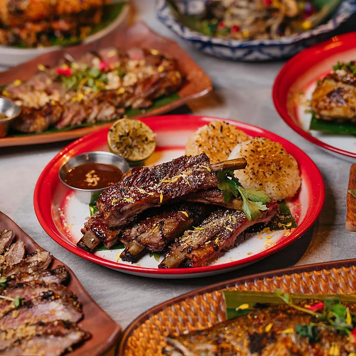 Fi's Signature "Moo Ping" Pork Rib ($48, 500g bone-in), slow-grilled over lychee wood until tender, then flame-kissed for the perfect charred ends. 