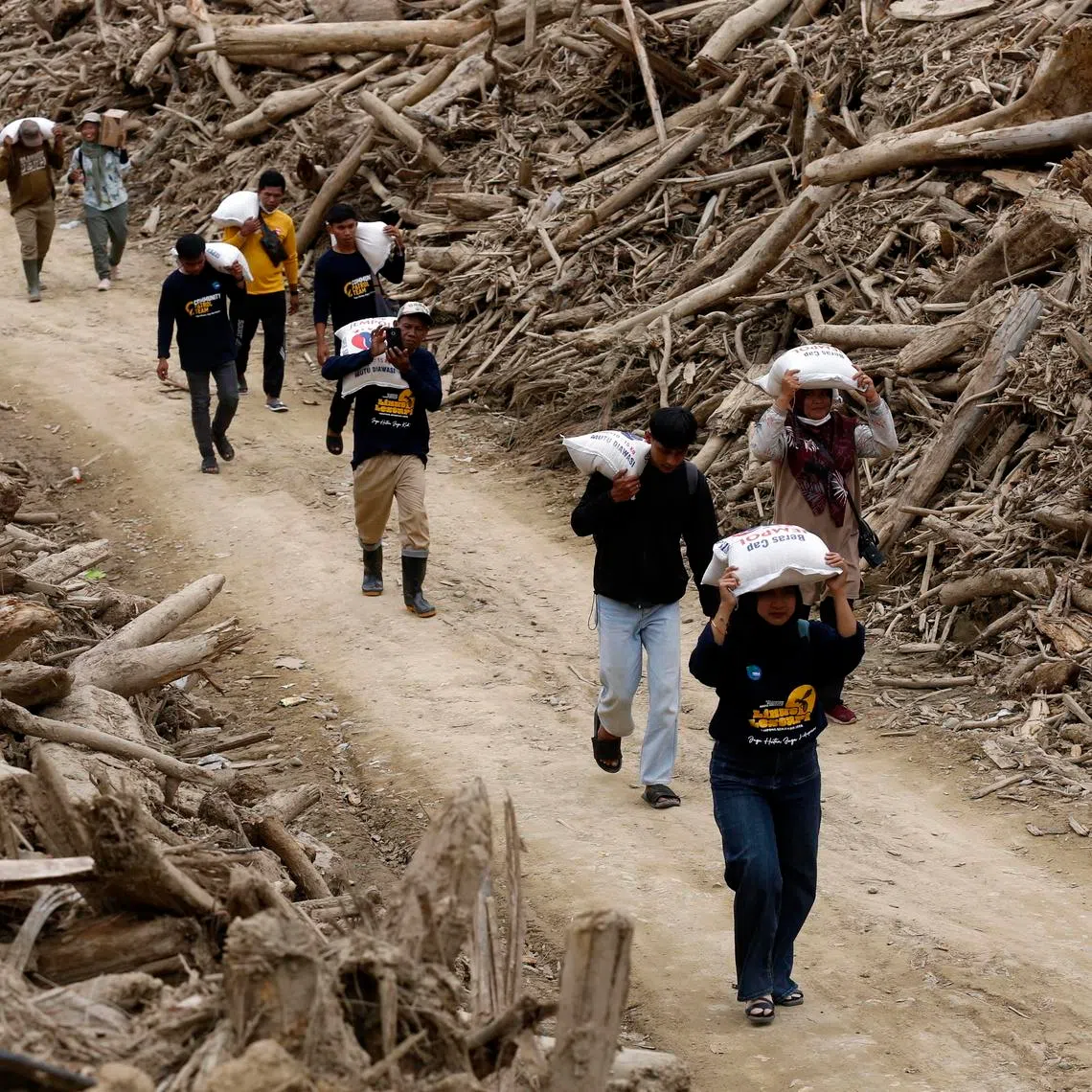 Volunteers distribute food aid at a flood-affected area in Aceh on Feb 6.