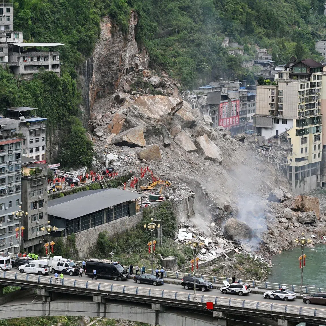 Rescue workers search for survivors at the site of a landslide along Wujiang river in Pengshui Miao and Tujia Autonomous County, Chongqing, on July 17.
