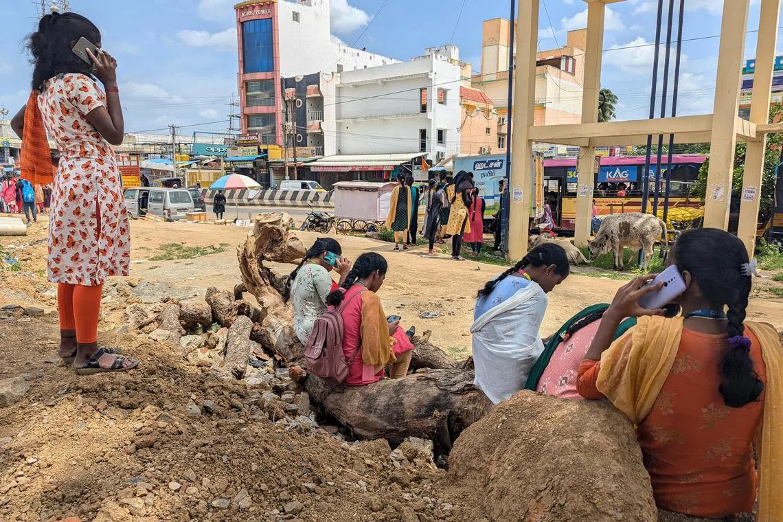 rmhousing - Women workers in Sriperumbudur industrial area in Tamil Nadu wait for their company bus.