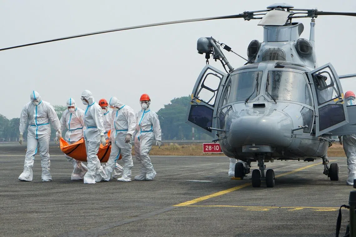 Rescuers carrying a body recovered from the Virgo Transport 8 ferry, which capsized on Sept 13, after arriving at Sjamsudin Noor air base in Banjarbaru, Indonesia, on Sept 28.