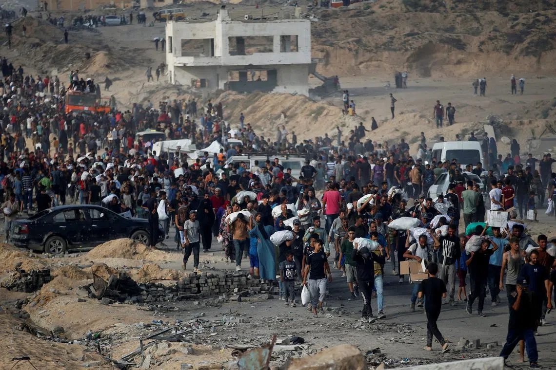 FILE PHOTO: Palestinians gather to receive aid supplies in Beit Lahia, northern Gaza Strip, June 22, 2025. REUTERS/Mahmoud Issa/File Photo