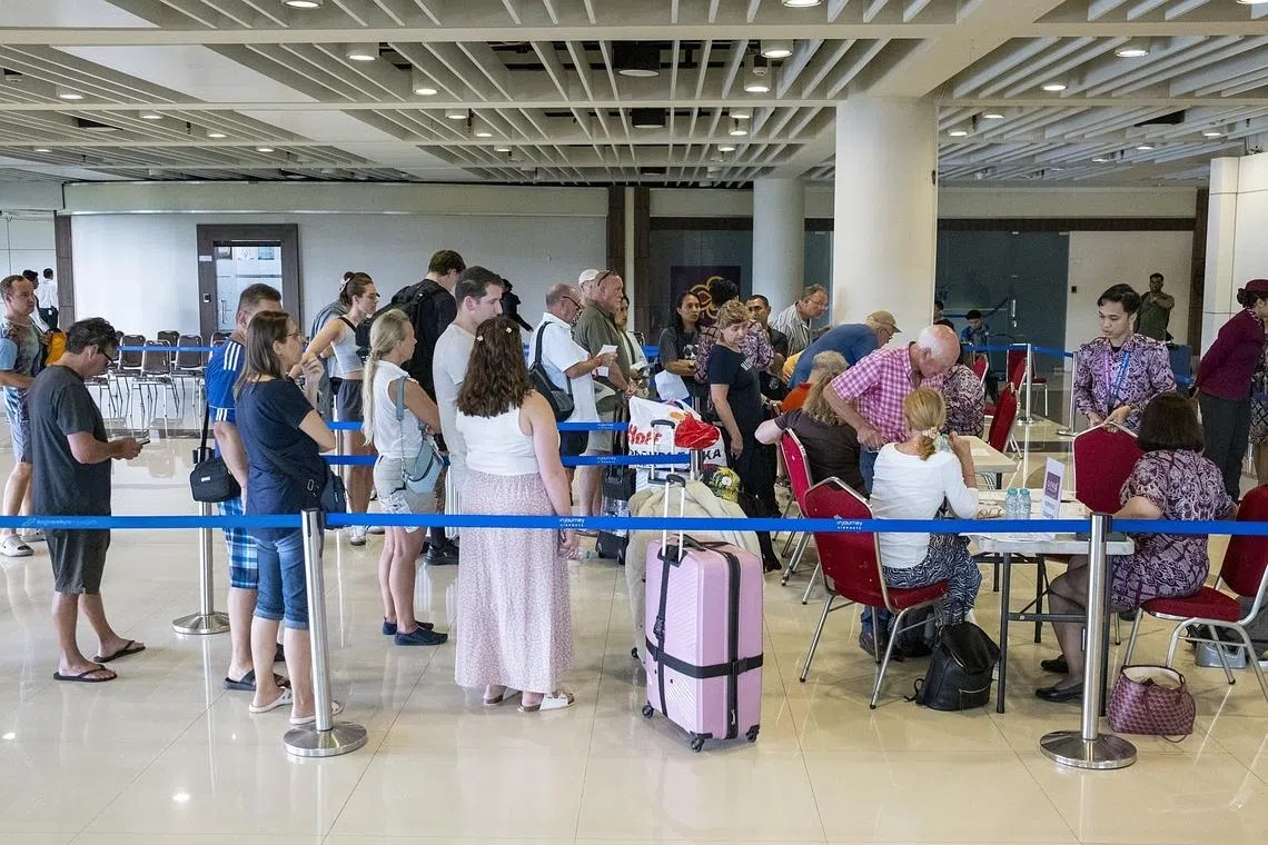 Passengers waiting for assistance from Qatar Airways staff after their flight was canceled at Ngurah Rai International Airport in Bali, Indonesia, on March 1.