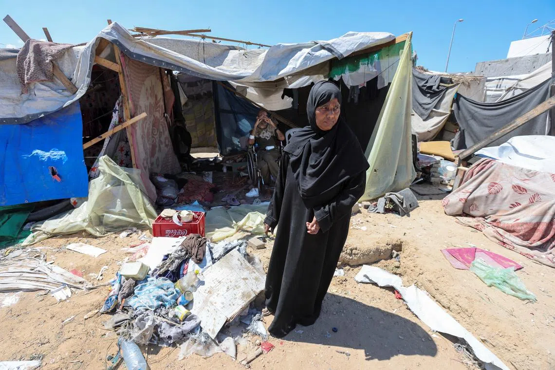 Displaced woman Iqbal Al-Zeidi stands in front of her tent which was torn by an Israeli strike, on the courtyard of Al-Aqsa Martyrs hospital, amid the Israel-Hamas conflict, in Deir Al-Balah in the central Gaza Strip, September 5, 2024. REUTERS/Ramadan Abed/File Photo