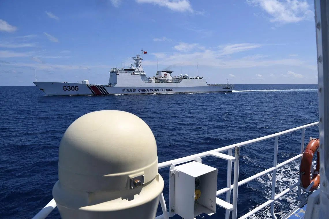 A Chinese coast guard ship (L) shadowed a Philippine coast guard ship BRP Cabra closely during a re-supply mission in the disputed South China Sea on August 22., 2023. 
