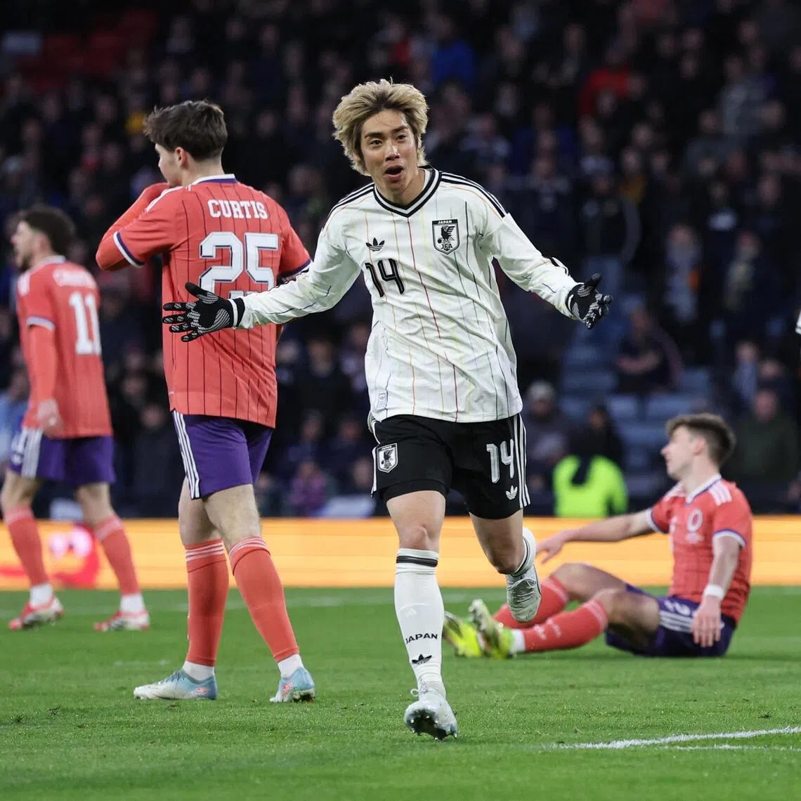 Japan's Junya Ito celebrates his late, winning goal against Scotland on March 28.