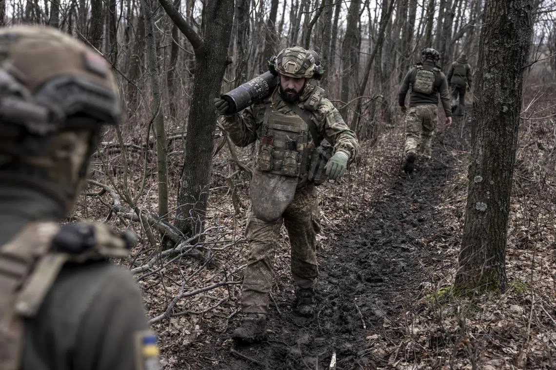 Members of a Ukrainian artillery crew move shells on the front line in the Donetsk region of Ukraine.