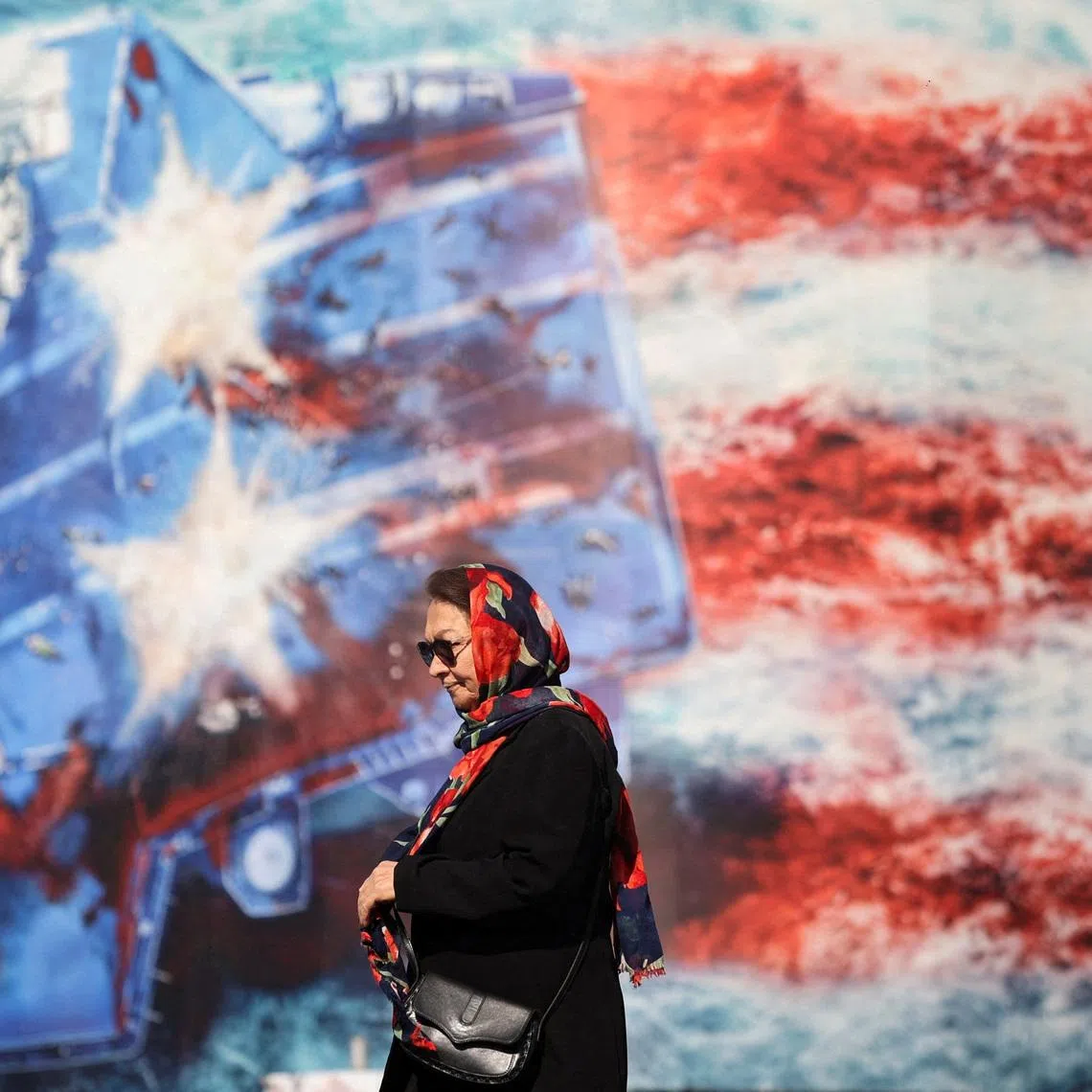 An Iranian woman walks past an anti-U.S. billboard in Tehran, Iran, February 26, 2026. Majid Asgaripour/WANA (West Asia News Agency) via REUTERS