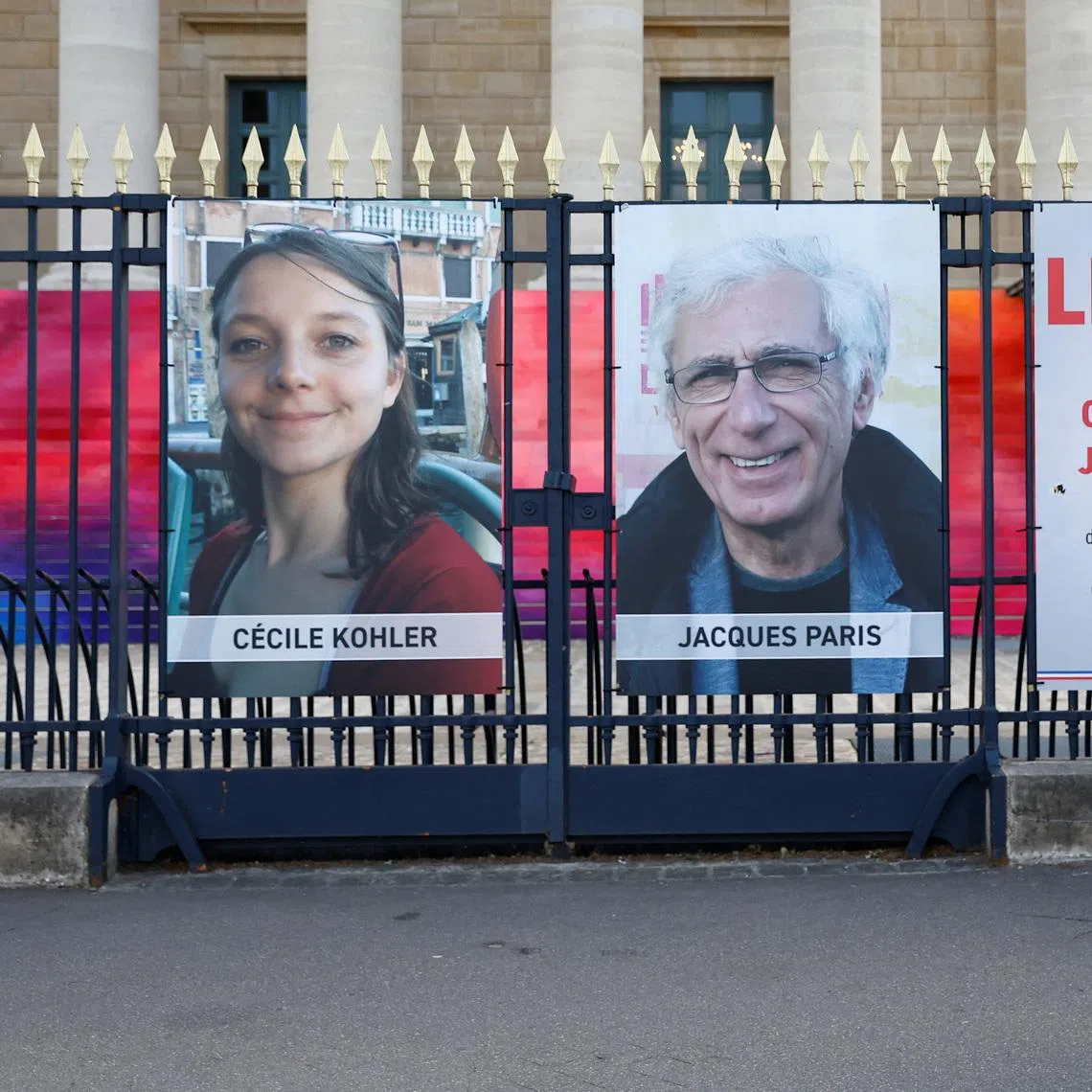 A woman walks past posters with the portraits of Cecile Kohler and Jacques Paris, two French citizens held in Iran, on the day of support rallies to mark their three-year detention and to demand their release, in front of the National Assembly in Paris, France, May 7, 2025.