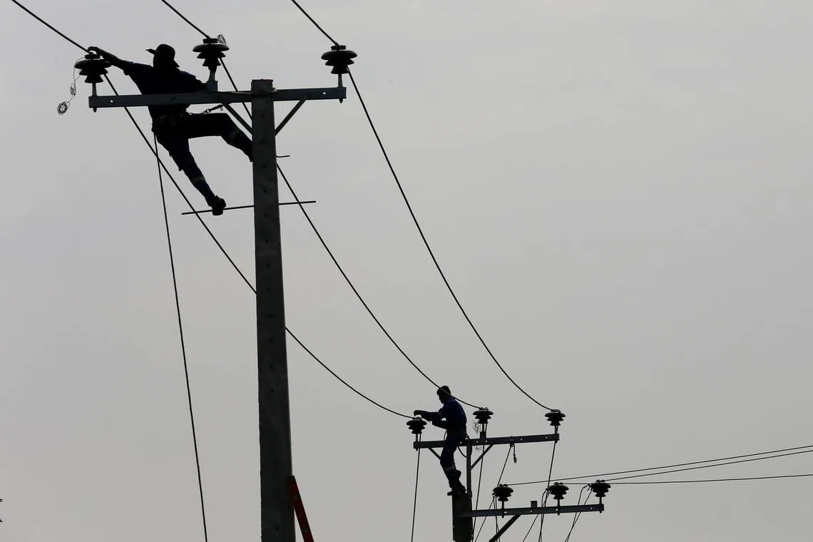 FILE PHOTO: Employees from eletricity board pull electric cables on top of electricity posts in Piliyandala, Sri Lanka November 29, 2016. REUTERS/Dinuka Liyanawatte/File Photo