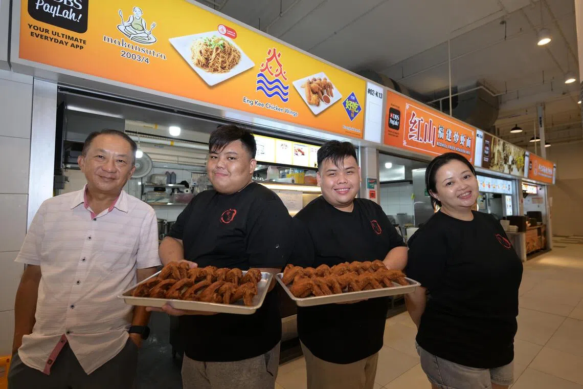 Brothers Brendan (second from left) and Nicholas Lim (third from  left) run the Eng Kee Chicken Wings stall at Buangkok Hawker Centre. They are with their aunt Jaslynn Puah, who runs another outlet, and uncle Jack Lim, who owns the franchise, 16 May 2024.