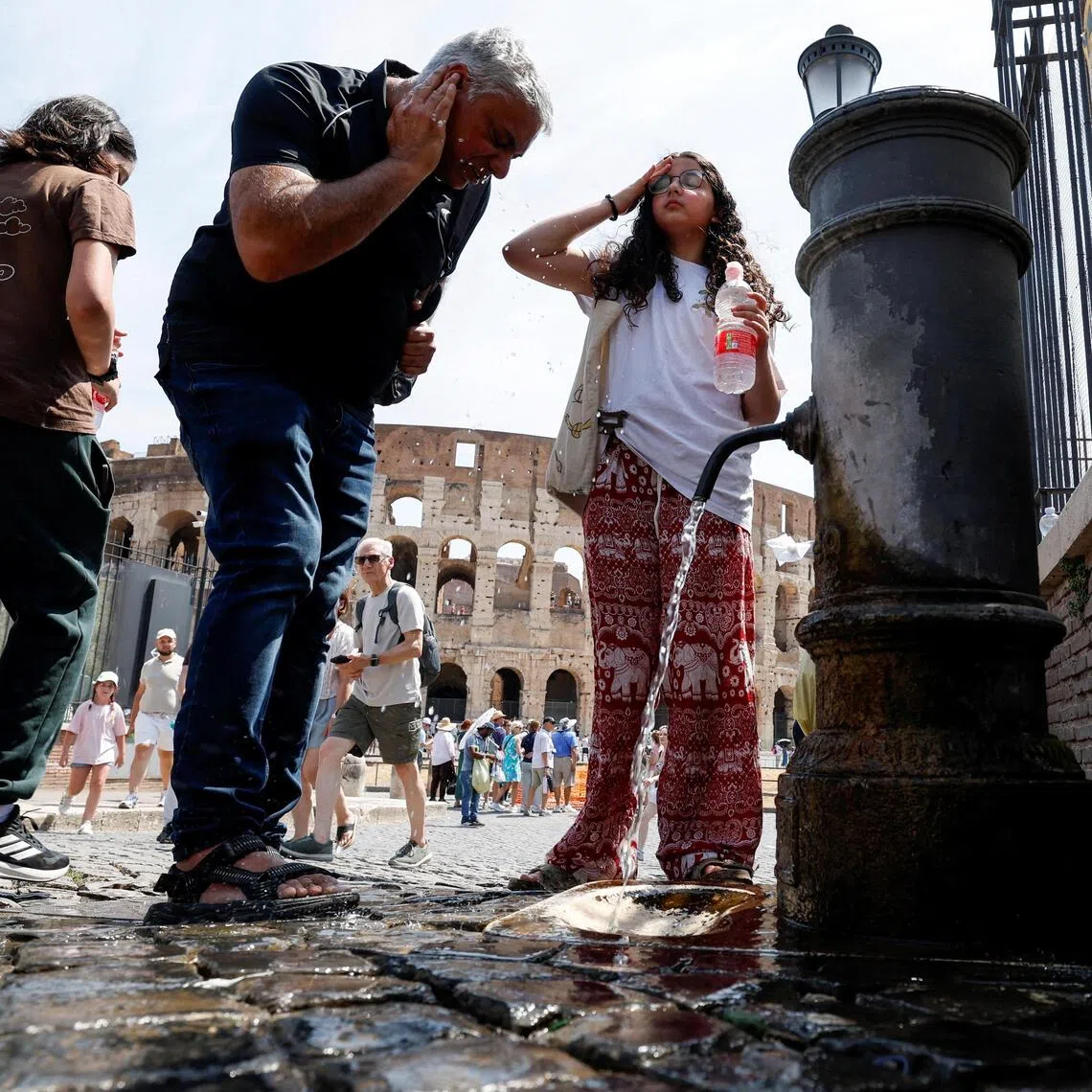 People cooling off near the Colosseum during a heatwave as temperatures are expected to rise further in the coming days, in Rome, Italy, on Aug 3.