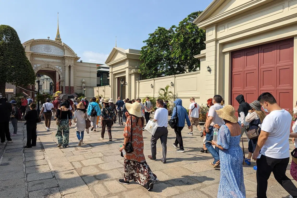 Chinese tour groups make their way into the Grand Palace in Bangkok.