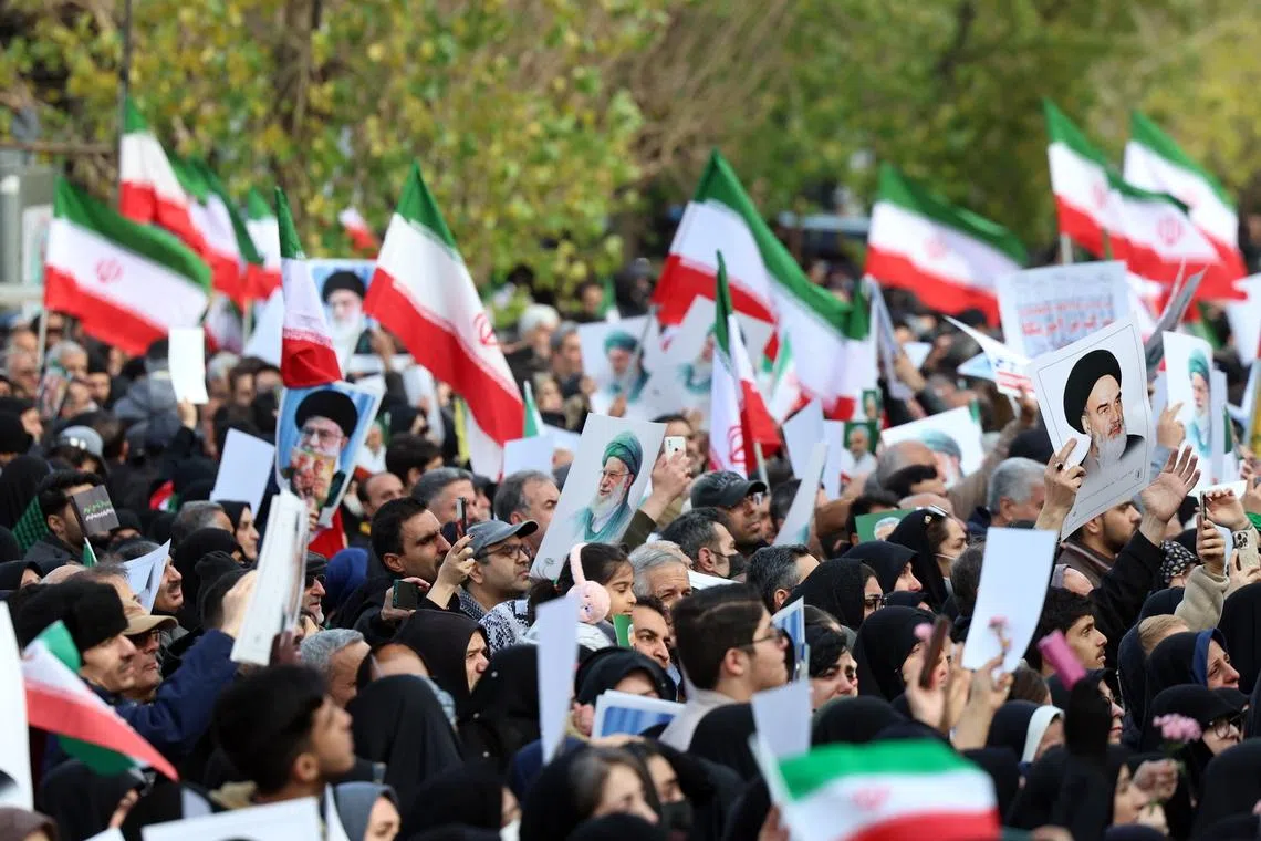 Mourners wave national flags and portraits of Iranian Supreme Leader Ayatollah Ali Khamenei during a funeral ceremony for security personnel killed during anti-government protests, in Tehran on Jan 14.