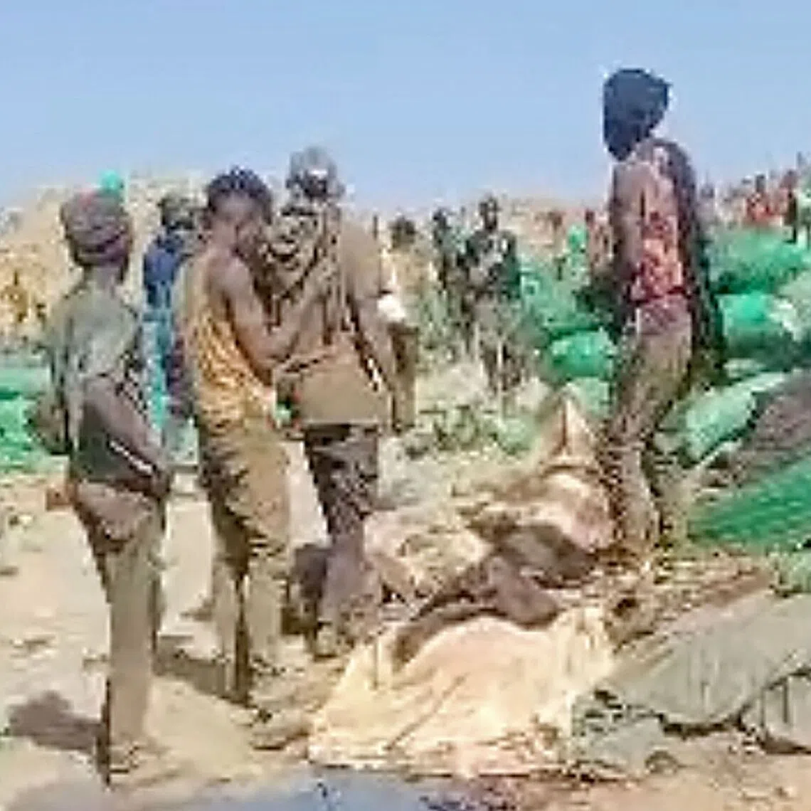 People inspecting the site of an airstrike in the mining area of Jabal al-Uqaydat, in Sudan, in a screengrab from a video obtained on Oct 12.