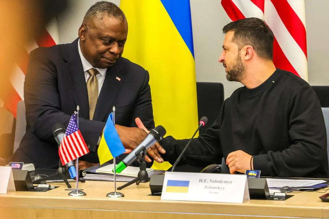 U.S. Secretary of Defense Lloyd Austin III shakes hands with Ukraine's President Volodymyr Zelenskiy during meeting of Ukraine Defense Contact Group ahead of a two day NATO Defense Ministers Council at the alliance headquarters in Brussels, Belgium, October 11, 2023.  Olivier Matthys/Pool via REUTERS