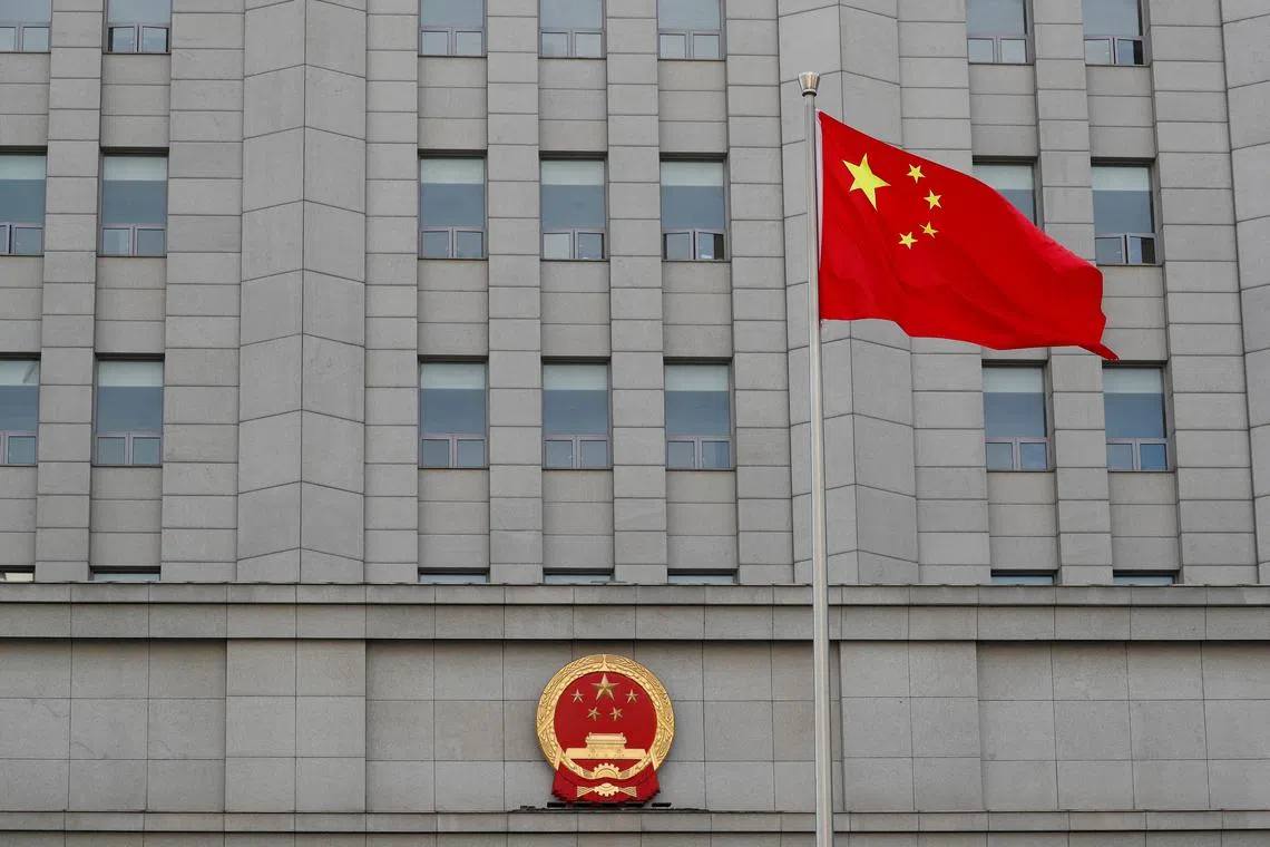 FILE PHOTO: A Chinese national flag waves outside Beijing No. 2 Intermediate People's Court where Australian writer Yang Hengjun is expected to face trial on espionage charges, in Beijing, China May 27, 2021. REUTERS/Carlos Garcia Rawlins