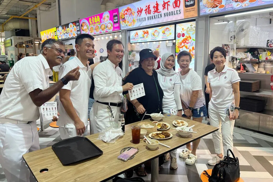 The PAP's Jurong East-Bukit Batok GRC candidates (from left) Murali Pillai, David Hoe, Lee Hong Chuang, Rahayu Mahzam (third from right) and Grace Fu (right) on a walkabout at Bukit Batok West Hawker Centre on April 29.