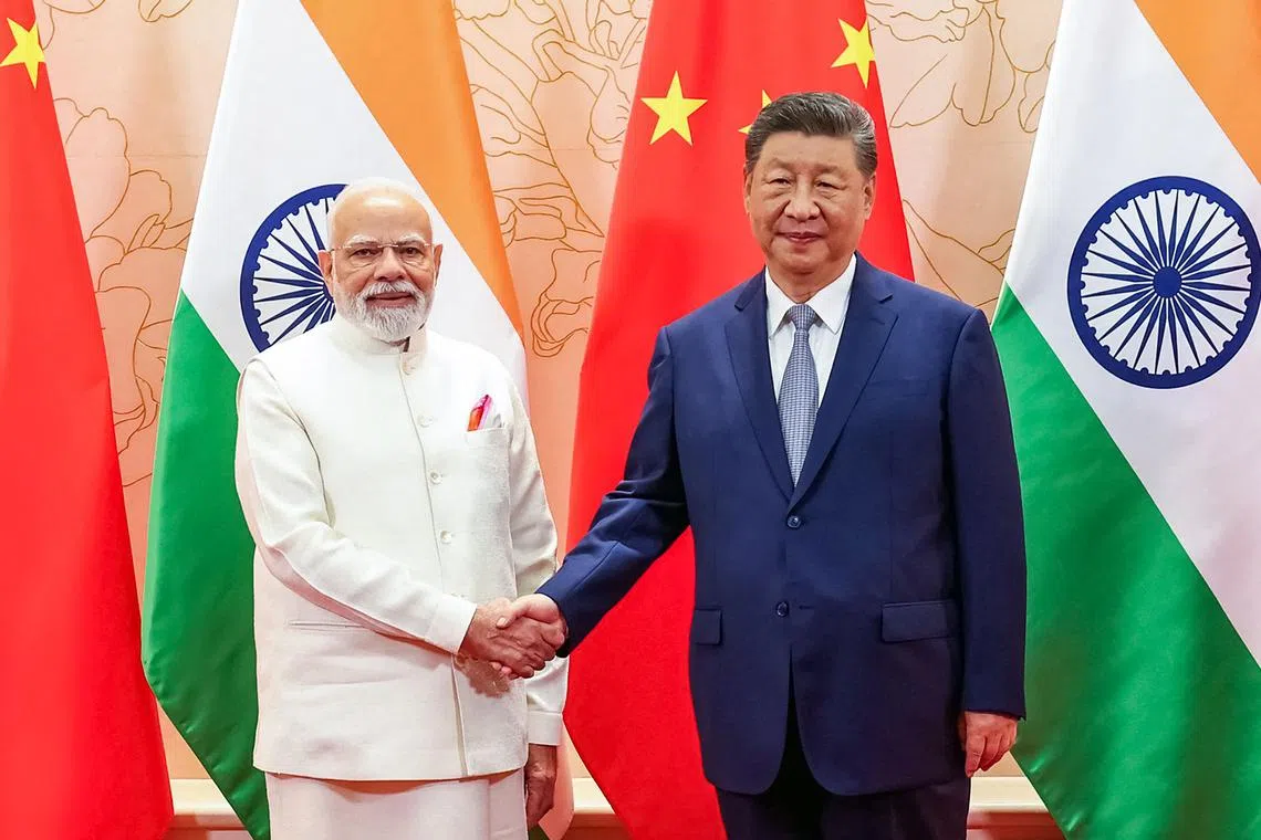In this handout photograph taken on August 31, 2025 and released by the Indian Press Information Bureau (PIB), India’s Prime Minister Narendra Modi (L) and China’s President Xi Jinping shake hands during a bilateral meeting on the sidelines of the Shanghai Cooperation Organisation (SCO) summit in Tianjin. Xi gathered the leaders of Russia and India among dignitaries from around 20 Eurasian countries on August 31, for a showpiece summit aimed at putting China front and centre of regional relations. (Photo by Indian Press Information Bureau (PIB) / AFP) / RESTRICTED TO EDITORIAL USE - MANDATORY CREDIT "AFP PHOTO / Indian Press Information Bureau (PIB) / - " - NO MARKETING NO ADVERTISING CAMPAIGNS - DISTRIBUTED AS A SERVICE TO CLIENTS