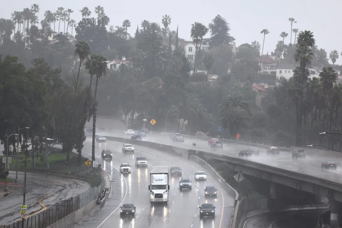 Vehicles drive through the heavy rain caused by another atmospheric river storm on the 101 freeway on Feb 19 in Los Angeles.