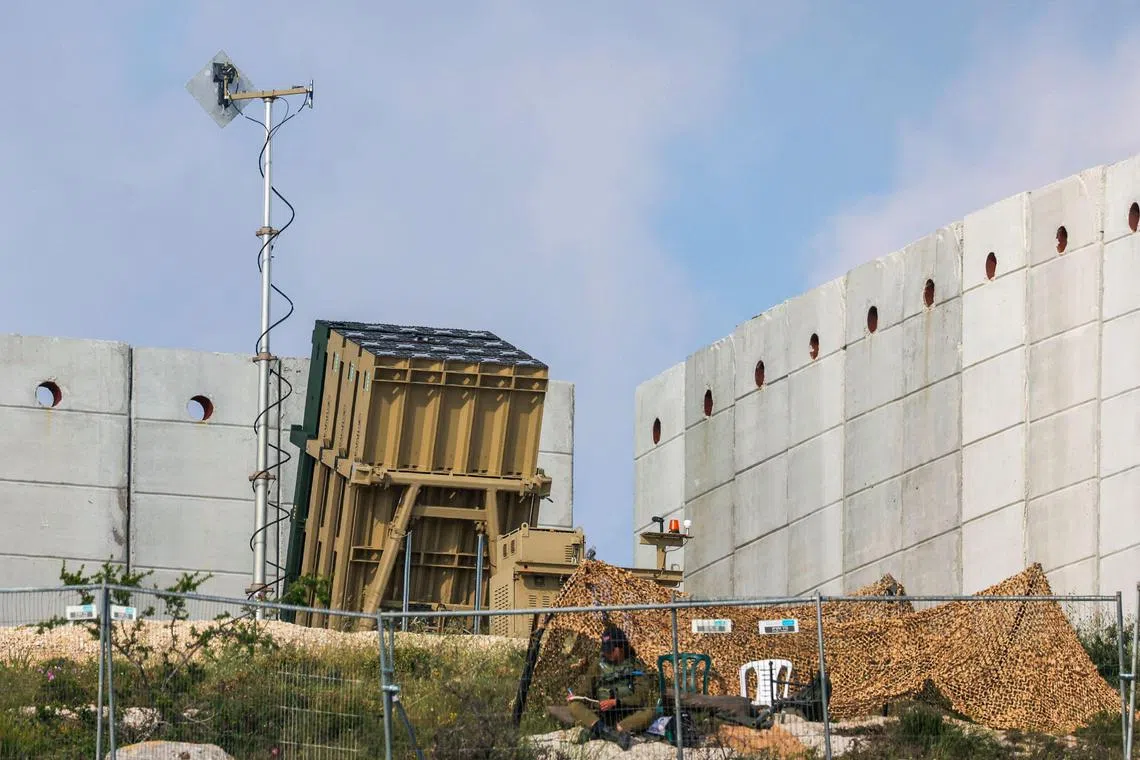 An Israeli soldier takes up a position in front of a battery of an Iron Dome air defence system near Jerusalem on April 15.